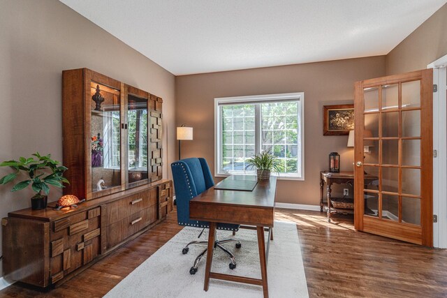 home office featuring dark wood-style flooring and baseboards