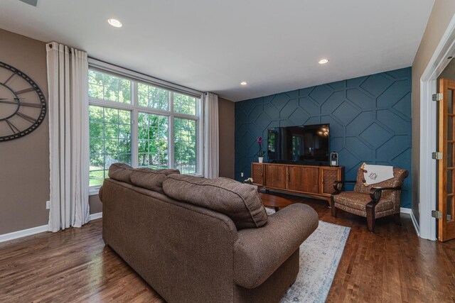 living room with an accent wall, plenty of natural light, baseboards, dark wood-style flooring, and recessed lighting