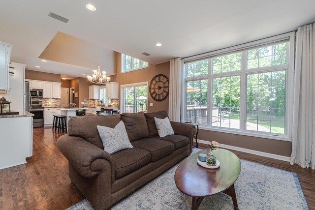 living room featuring a chandelier, dark wood finished floors, recessed lighting, and baseboards