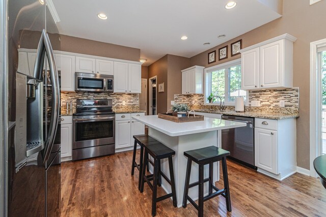 kitchen with stainless steel appliances, tasteful backsplash, white cabinetry, and recessed lighting