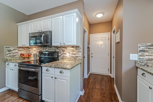 kitchen with appliances with stainless steel finishes, dark wood-type flooring, and tasteful backsplash
