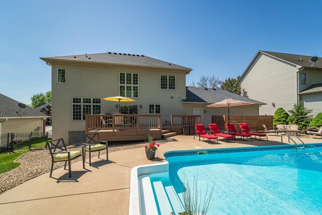 view of pool with a wooden deck, a patio area, fence, and an outdoor living space