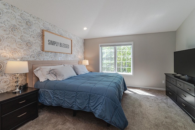 carpeted bedroom with baseboards and lofted ceiling