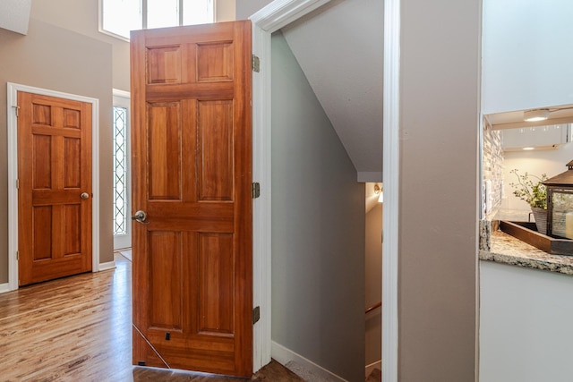 foyer entrance with light wood-type flooring, plenty of natural light, and baseboards