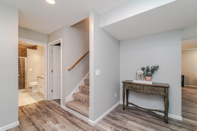 stairway featuring wood finished floors and baseboards