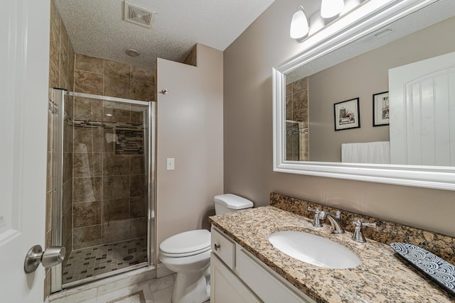 full bathroom with a shower stall, toilet, vanity, and a textured ceiling