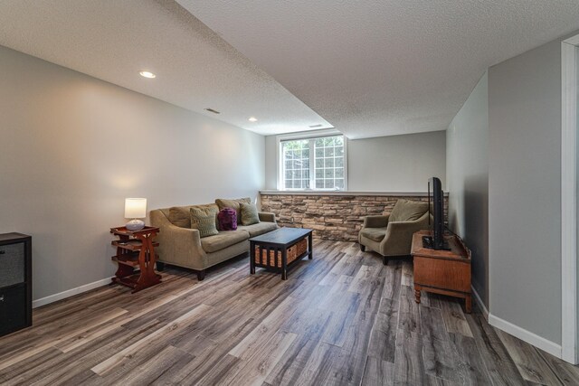 living area with wood finished floors, a textured ceiling, baseboards, and recessed lighting