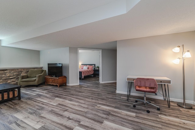 office with wood finished floors, baseboards, and a textured ceiling