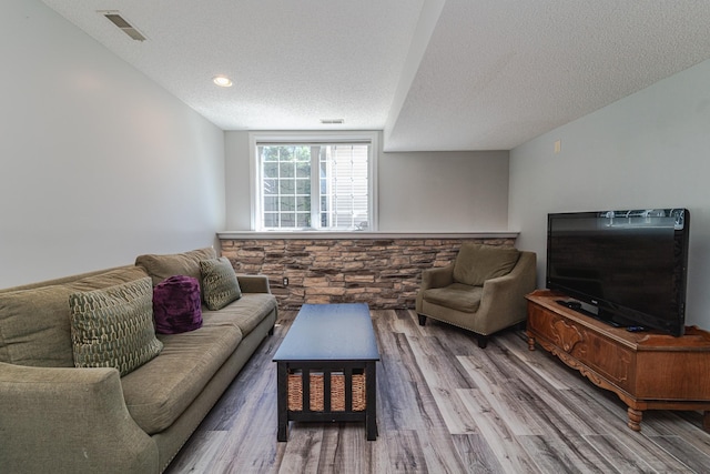 living area with a textured ceiling, wood finished floors, and recessed lighting