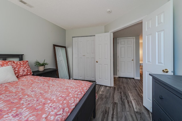 bedroom with dark wood-style flooring, a closet, and a textured ceiling