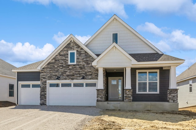 craftsman-style house with an attached garage, a shingled roof, stone siding, and dirt driveway
