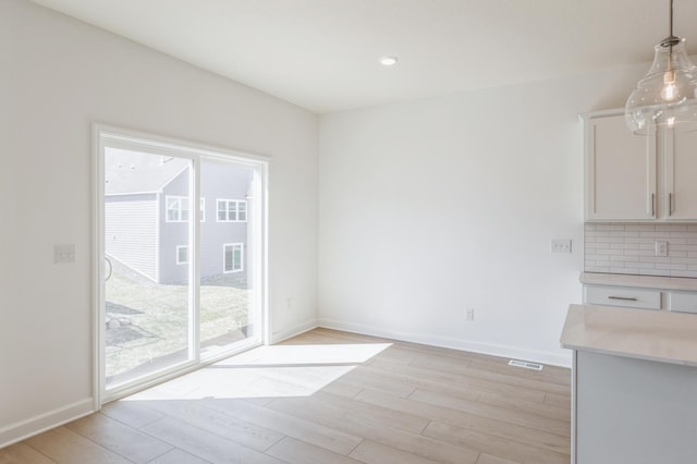 unfurnished dining area with visible vents, baseboards, recessed lighting, and light wood-style floors
