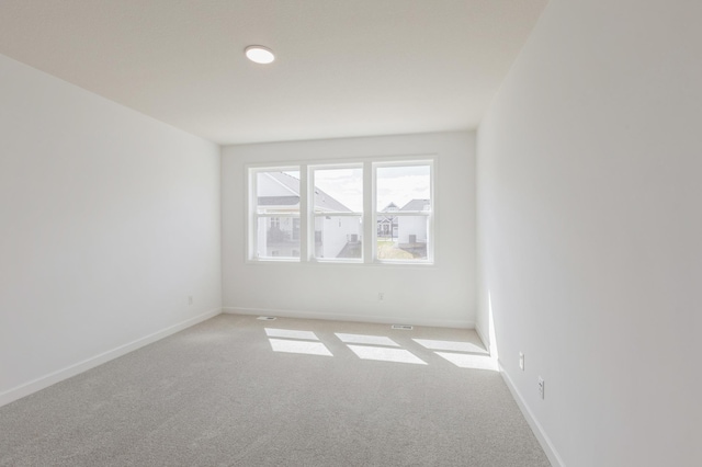 carpeted empty room featuring baseboards