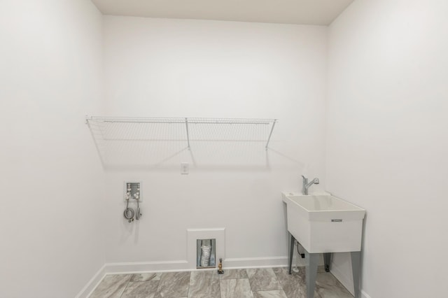 washroom featuring washer hookup, marble finish floor, baseboards, and laundry area