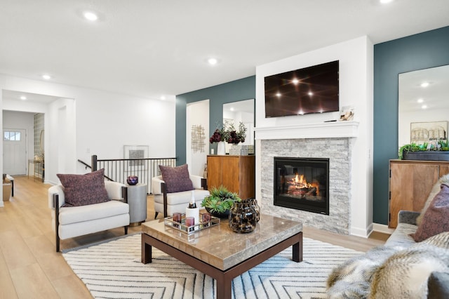 living room featuring a fireplace, light wood finished floors, and recessed lighting