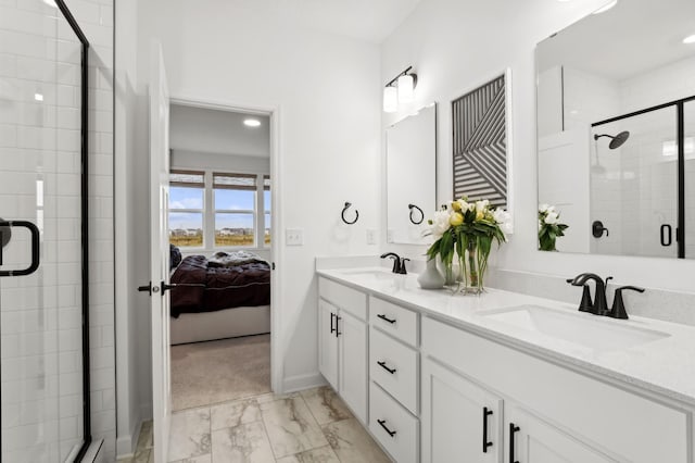 bathroom with double vanity, a shower stall, marble finish floor, and a sink
