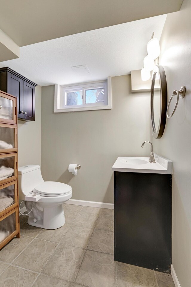 half bath featuring vanity and toilet