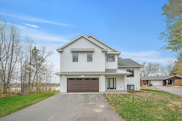 modern farmhouse style home featuring driveway, board and batten siding, a front lawn, a standing seam roof, and metal roof