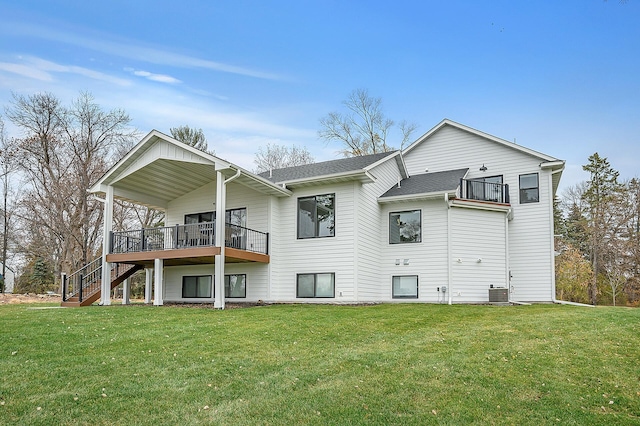 back of property with central air condition unit, roof with shingles, a yard, and stairs