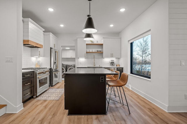 kitchen featuring high end appliances, separate washer and dryer, open shelves, and white cabinetry