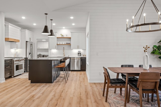 kitchen featuring high quality appliances, light wood-style flooring, open shelves, a kitchen island, and white cabinets