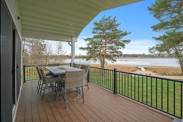 deck featuring a yard, outdoor dining space, and a water view