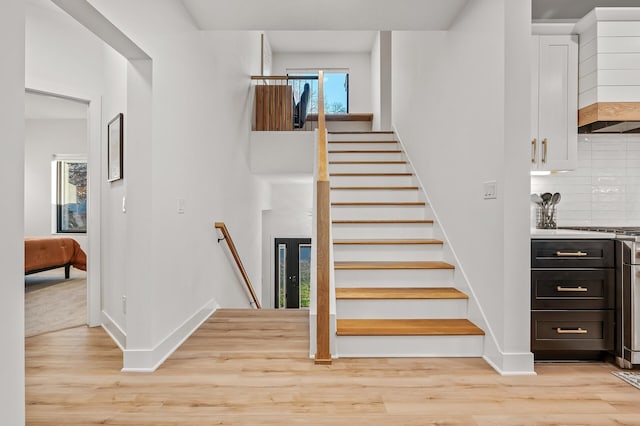 staircase with baseboards and wood finished floors