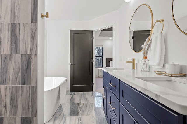 full bathroom featuring a soaking tub, double vanity, and a sink
