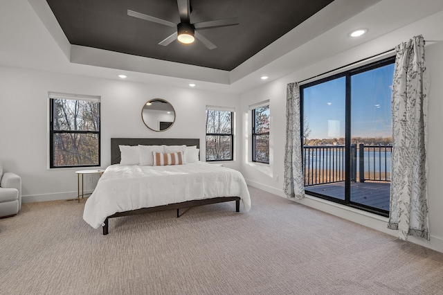 carpeted bedroom featuring access to outside, baseboards, recessed lighting, a raised ceiling, and ceiling fan