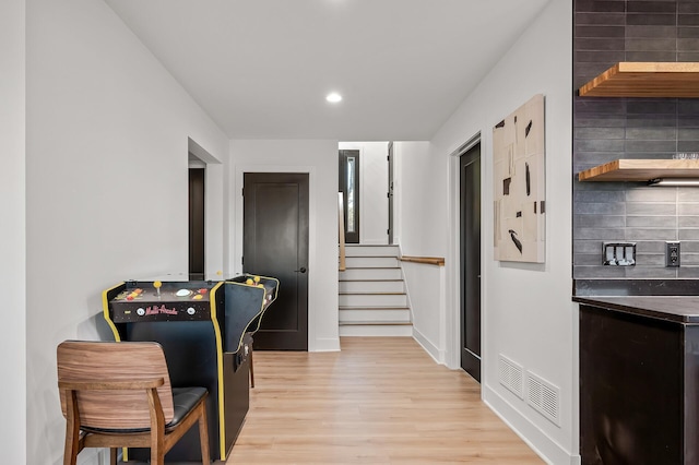 interior space featuring visible vents, baseboards, light wood finished floors, recessed lighting, and stairs
