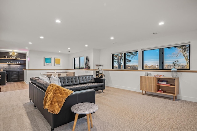 living room featuring a healthy amount of sunlight, indoor bar, baseboards, and recessed lighting