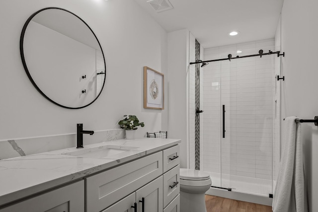 full bath with vanity, visible vents, toilet, wood finished floors, and a stall shower