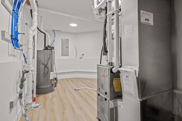 utility room featuring electric panel, water heater, and heating unit