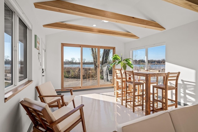 dining space with lofted ceiling with beams
