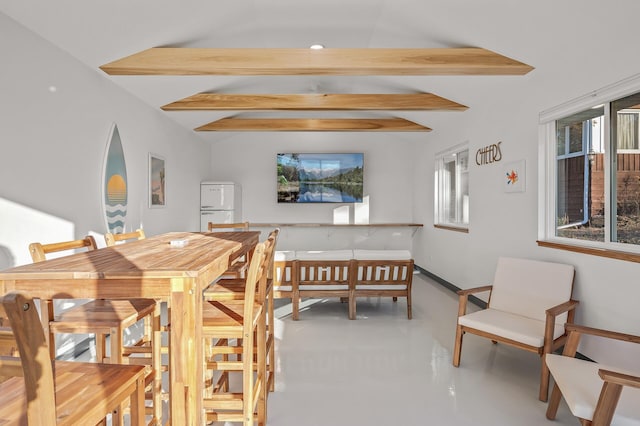 dining room with vaulted ceiling with beams and finished concrete floors