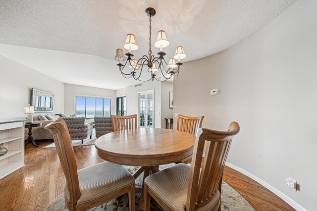 2950 Dean Pkwy Unit 2005, Minneapolis, MN 55416 - dining area featuring a chandelier, baseboards, a textured ceiling, and light wood finished floors