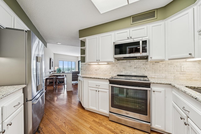 2950 Dean Pkwy Unit 2005, Minneapolis, MN 55416 - kitchen with appliances with stainless steel finishes, white cabinetry, light wood-style flooring, tasteful backsplash, and recessed lighting
