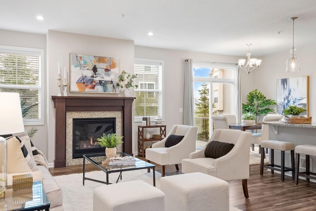 sitting room with recessed lighting, a glass covered fireplace, wood finished floors, and a chandelier