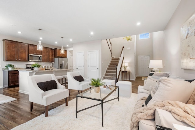 living room featuring recessed lighting, stairs, and wood finished floors