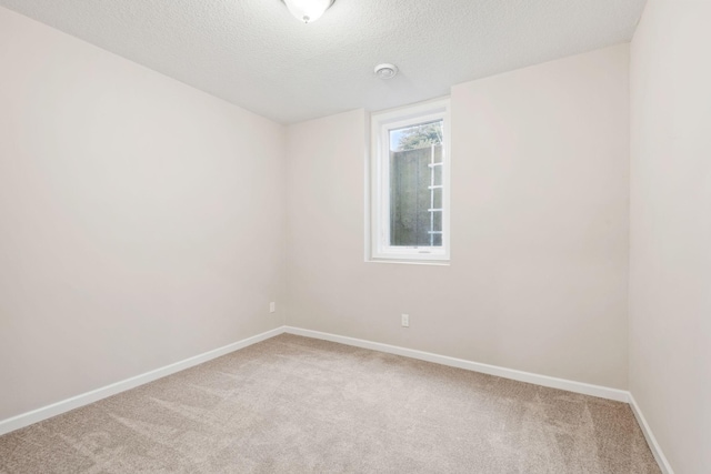 unfurnished room with baseboards, light carpet, and a textured ceiling