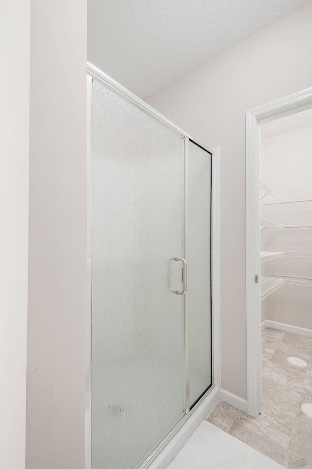 full bathroom with a stall shower and a spacious closet