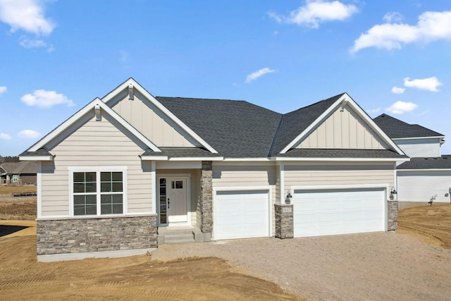 craftsman house featuring driveway, stone siding, board and batten siding, an attached garage, and roof with shingles