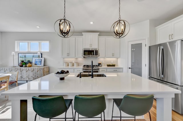 kitchen with an inviting chandelier, appliances with stainless steel finishes, tasteful backsplash, and a sink