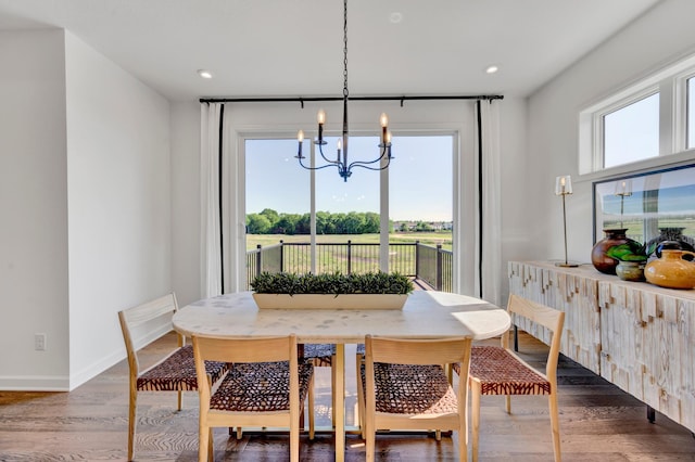 dining space with a chandelier, wood finished floors, baseboards, and recessed lighting
