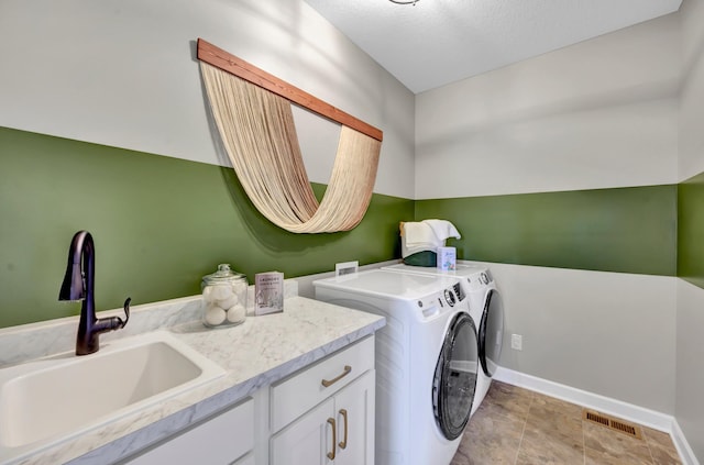 laundry room featuring cabinet space, baseboards, separate washer and dryer, and a sink