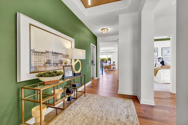 hall with baseboards and wood finished floors