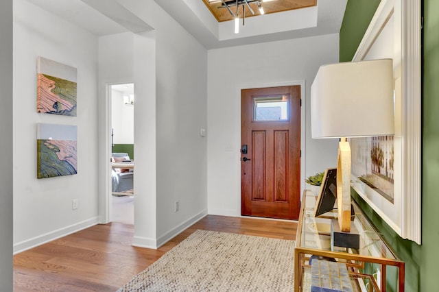 foyer with baseboards and wood finished floors