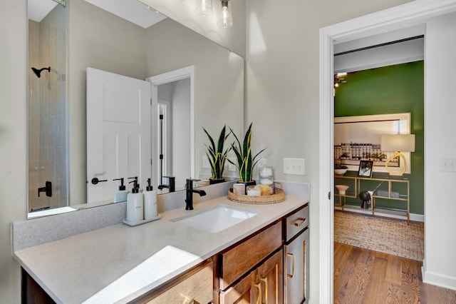full bathroom featuring baseboards, vanity, wood finished floors, and a shower
