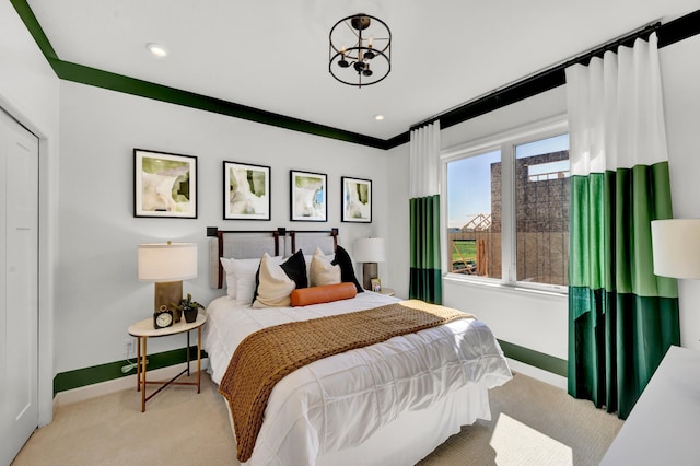 carpeted bedroom featuring baseboards and an inviting chandelier