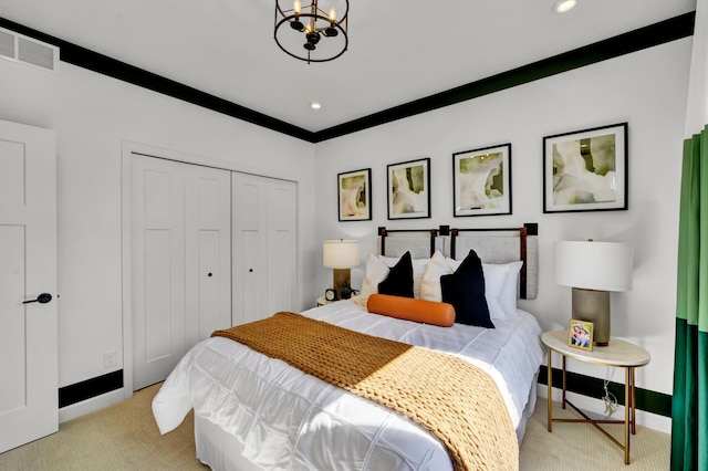 bedroom featuring a closet, an inviting chandelier, light colored carpet, baseboards, and visible vents